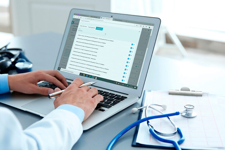 Arzt mit Software am Schreibtisch Arzt mit Software am Schreibtisch